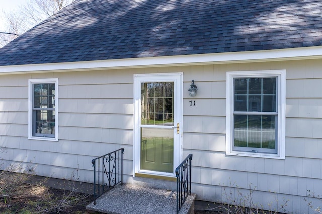 property entrance featuring a shingled roof