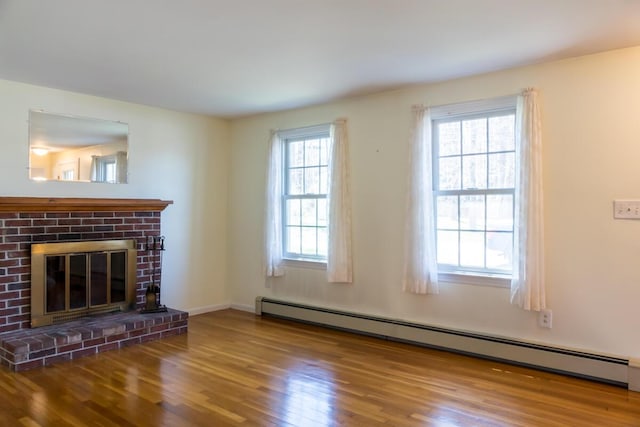 unfurnished living room featuring a fireplace, baseboards, baseboard heating, and wood finished floors