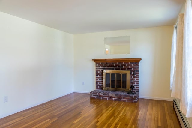 unfurnished living room with baseboards, a baseboard radiator, a brick fireplace, and hardwood / wood-style floors