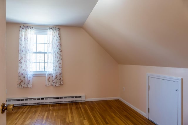 bonus room with baseboards, a baseboard radiator, vaulted ceiling, and wood finished floors