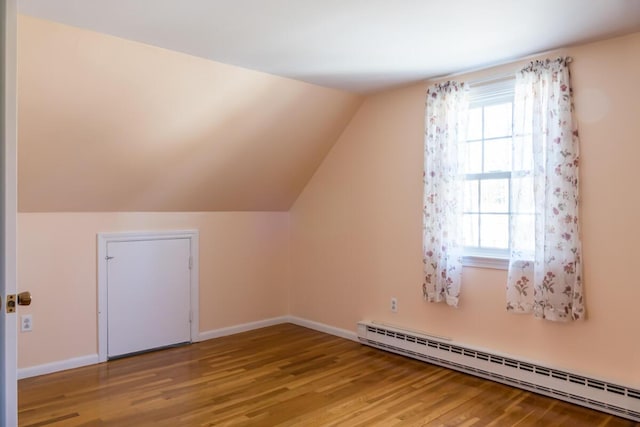 additional living space featuring baseboards, a baseboard radiator, lofted ceiling, and wood finished floors