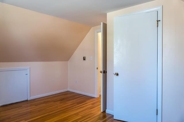 additional living space with baseboards, vaulted ceiling, and wood finished floors
