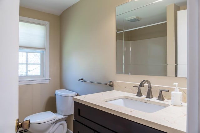 full bath featuring toilet, walk in shower, and vanity
