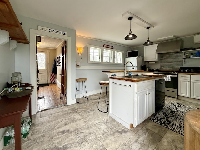 12 Prince Ave, Eastport, ME 04631 - kitchen with stainless steel range with electric cooktop, a sink, wall chimney exhaust hood, wooden counters, and white cabinetry