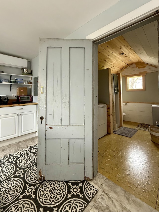 12 Prince Ave, Eastport, ME 04631 - hallway with vaulted ceiling, electric panel, a wall mounted AC, and washer / dryer