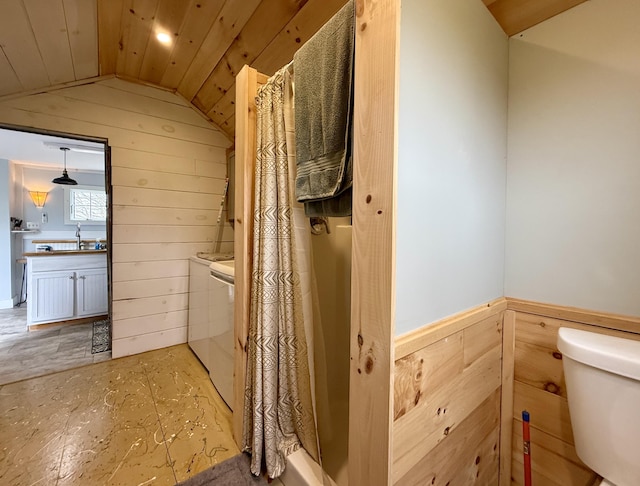 12 Prince Ave, Eastport, ME 04631 - bathroom featuring lofted ceiling, wooden walls, washer and clothes dryer, toilet, and a sink