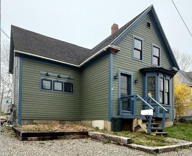 12 Prince Ave, Eastport, ME 04631 - view of side of property with a chimney, central AC, and roof with shingles