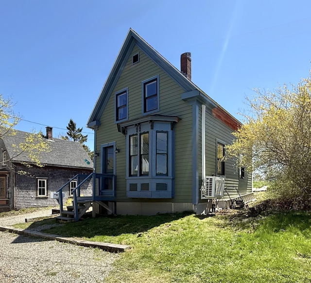 12 Prince Ave, Eastport, ME 04631 - rear view of house featuring a chimney and a yard