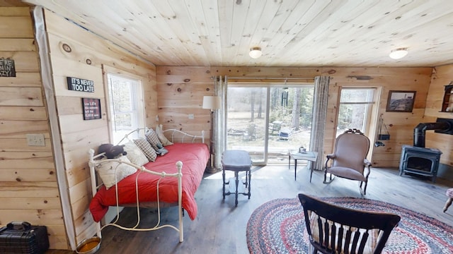 305 Main St N, Searsmont, ME 04973 - bedroom with a wood stove, wood finished floors, wooden walls, and multiple windows