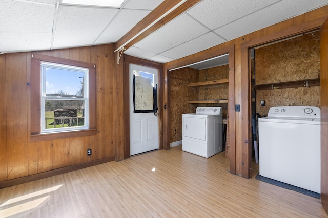 laundry room with baseboards, wood walls, and light wood-type flooring