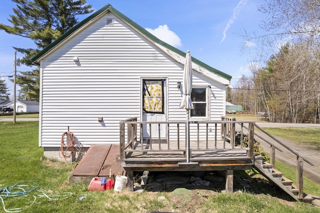 back of house featuring a wooden deck and a yard