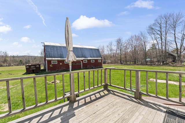 deck featuring a barn, an outdoor structure, and a lawn