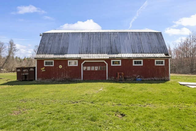 exterior space featuring a barn, an outdoor structure, a front lawn, and metal roof