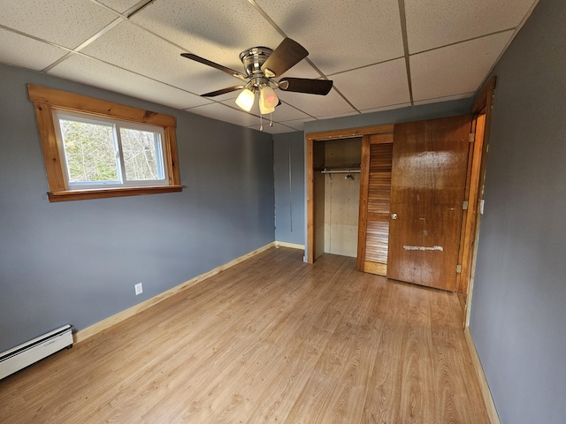57 Owlsboro Rd, Mount Chase, ME 04765 - unfurnished bedroom with a baseboard radiator, a closet, baseboards, a drop ceiling, and wood finished floors