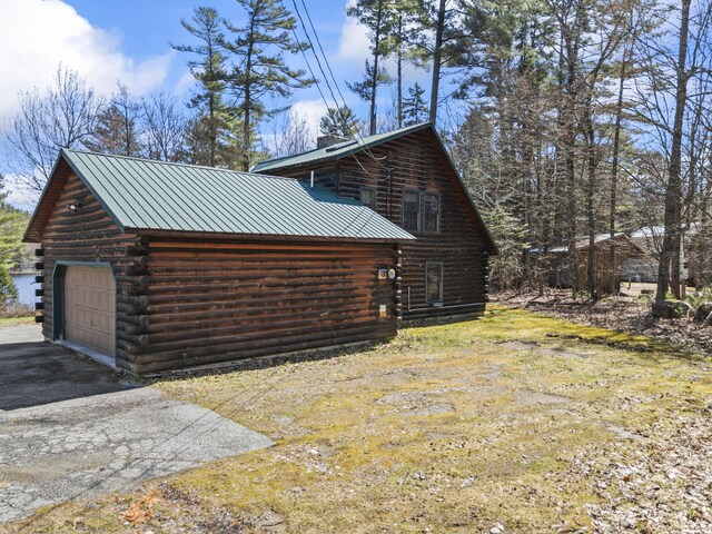 48 Thistle Ln, Sidney, ME 04330 - view of side of property with log siding, a detached garage, metal roof, and asphalt driveway