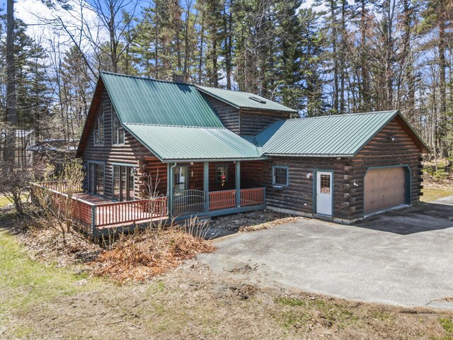 48 Thistle Ln, Sidney, ME 04330 - log-style house with log siding, driveway, metal roof, and a porch
