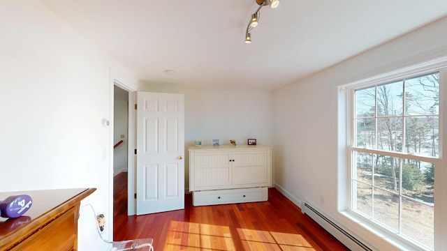 bedroom featuring baseboard heating and wood finished floors