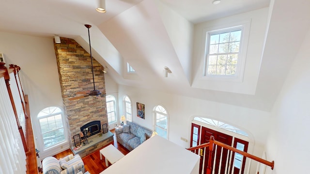 living area with high vaulted ceiling, wood finished floors, and recessed lighting