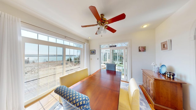 dining space with recessed lighting, a ceiling fan, and a water view