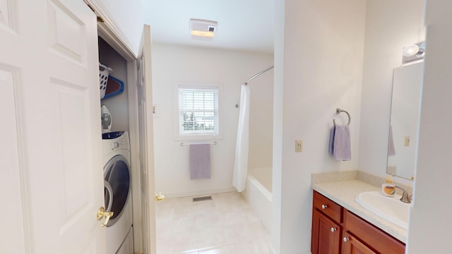full bathroom featuring tile patterned floors, shower / bath combo with shower curtain, vanity, visible vents, and washer / clothes dryer