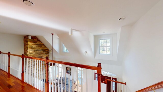 hallway with lofted ceiling and wood finished floors