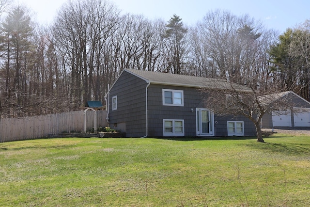 bi-level home featuring fence and a front lawn