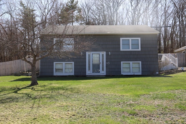 bi-level home with fence and a front yard