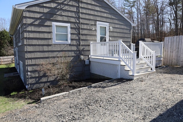 view of side of home featuring fence and a wooden deck