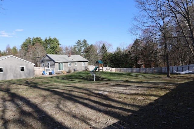 view of yard with a fenced backyard and a playground