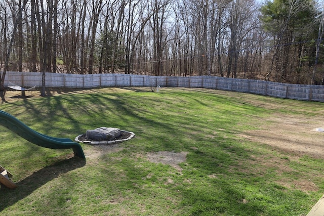 view of yard with a fenced backyard and an outdoor fire pit