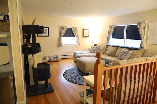 living room with baseboard heating, a textured ceiling, and wood finished floors