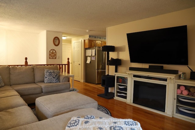 living area featuring light wood-type flooring and a textured ceiling