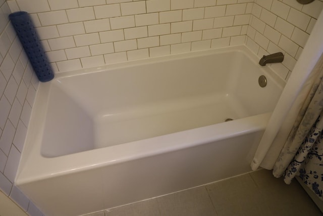 bathroom featuring a tub, tile patterned flooring, and curtained shower