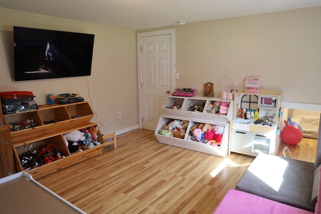 rec room featuring baseboards and wood finished floors