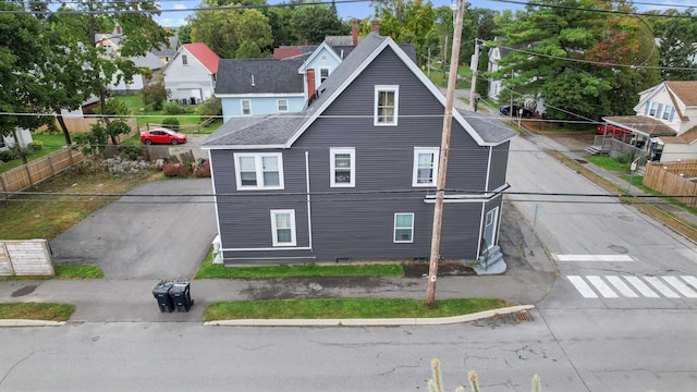 view of home's exterior featuring fence and roof with shingles