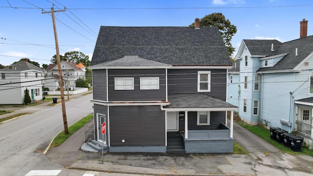 view of front of property with covered porch, entry steps, a shingled roof, and a residential view