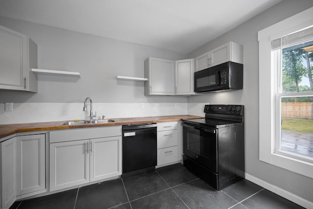 kitchen featuring black appliances, butcher block counters, open shelves, and a sink