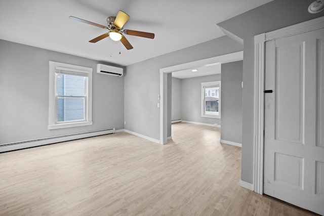 empty room featuring a baseboard radiator, a wall unit AC, and baseboards