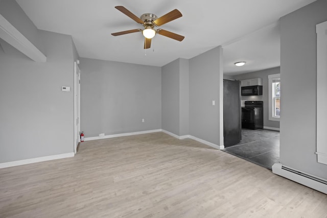 interior space featuring a baseboard heating unit, ceiling fan, wood finished floors, and baseboards