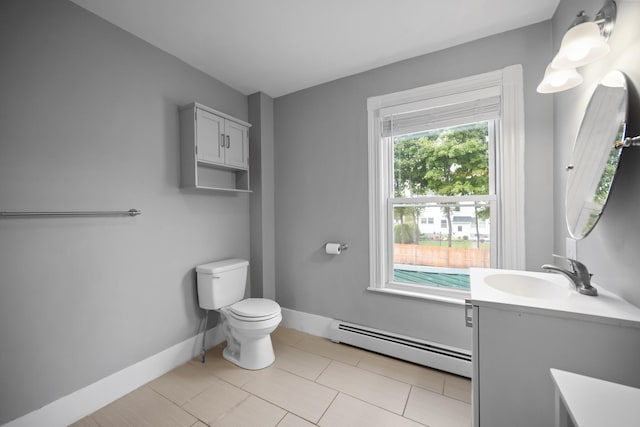 half bathroom featuring toilet, baseboard heating, vanity, and baseboards