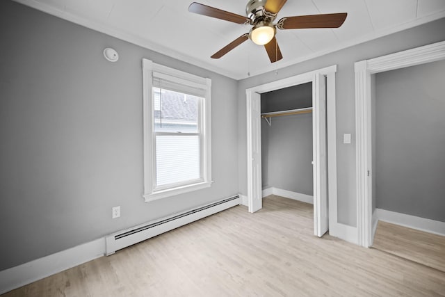 unfurnished bedroom with a baseboard heating unit, light wood-style floors, a closet, a ceiling fan, and baseboards