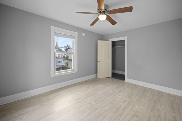 unfurnished bedroom featuring a closet, wood finished floors, and baseboards