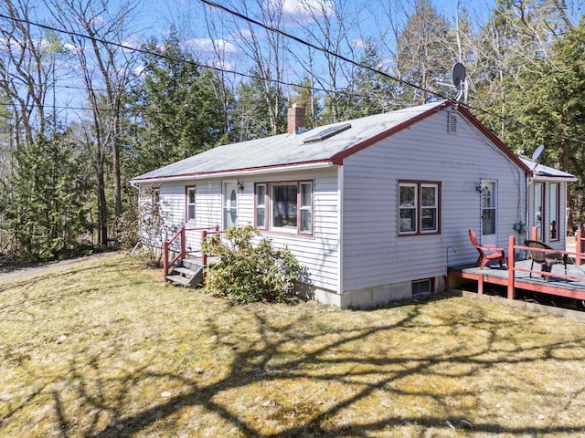 view of property exterior with a deck, a yard, and a chimney