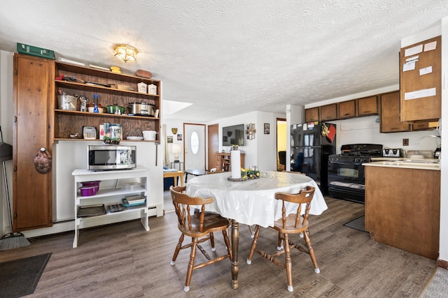 dining area featuring a textured ceiling and dark wood-style floors