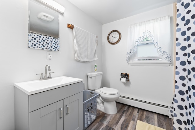 full bathroom featuring wood finished floors, a baseboard heating unit, toilet, vanity, and curtained shower