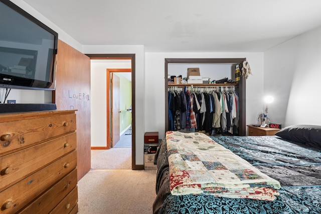 carpeted bedroom featuring baseboards and a closet
