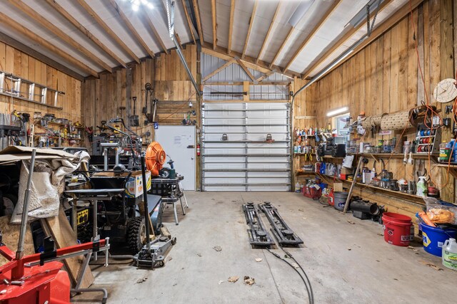 garage with a workshop area and wooden walls