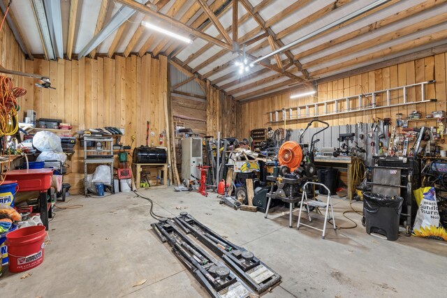 garage with a workshop area and wooden walls