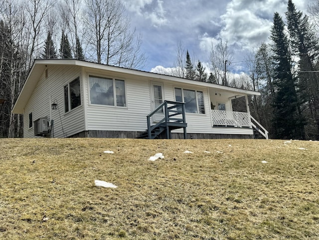 view of front of property featuring a front lawn and ac unit