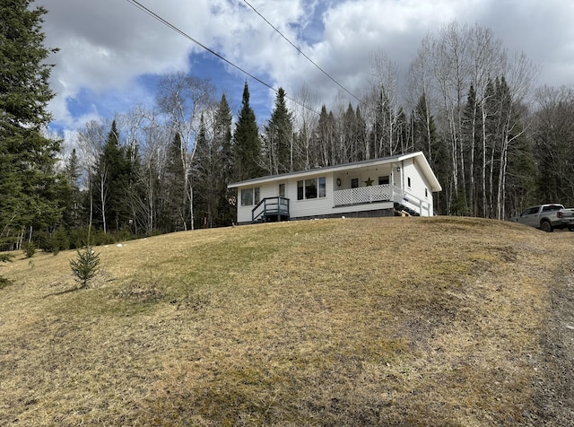 view of front of property with a front yard and a wooded view